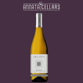 Wine bottle with yellow liquid, white label, foil cap, and dark base