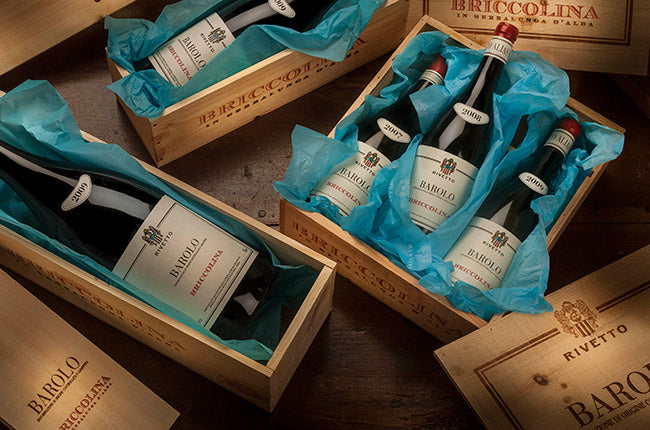 Wooden wine crate with multiple Barolo Riserva bottles and gift-style boxes