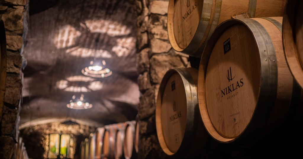 Wood wine barrels with bungholes and brand markings in a cellar