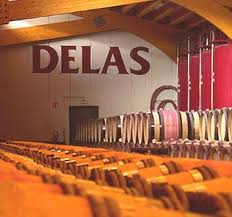 Wine bottles lined in a cellar with DELAS sign above