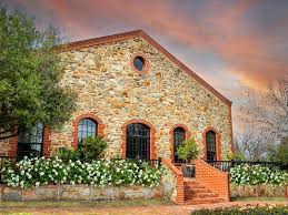 Brick winery building with arched windows and garden planters
