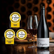 Syrah wine bottle with two wine glasses and circular award stickers