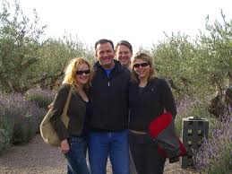 Three people standing outdoors in an olive grove