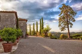 Tuscany countryside road with stone farmhouse and cypress trees