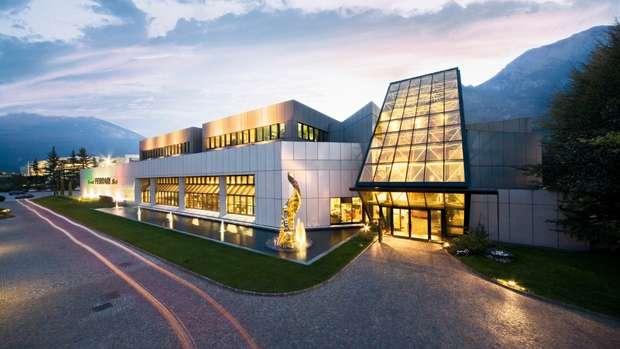Winery building with illuminated windows and modern glass facade at dusk