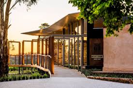 Winery building entrance with covered walkway and gate, viewed from the driveway